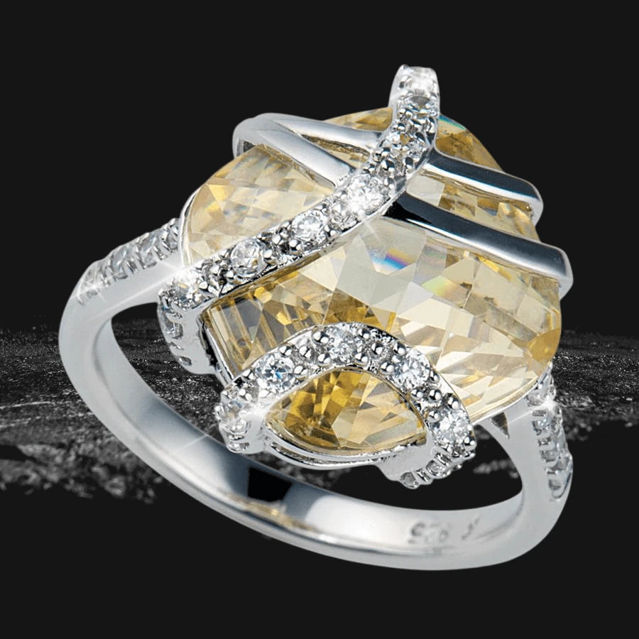 Sunrise Ring featuring a sterling silver band adorned with sparkling crystals, showcasing a large faceted yellow gemstone in an elegant design for female jewelry lovers.