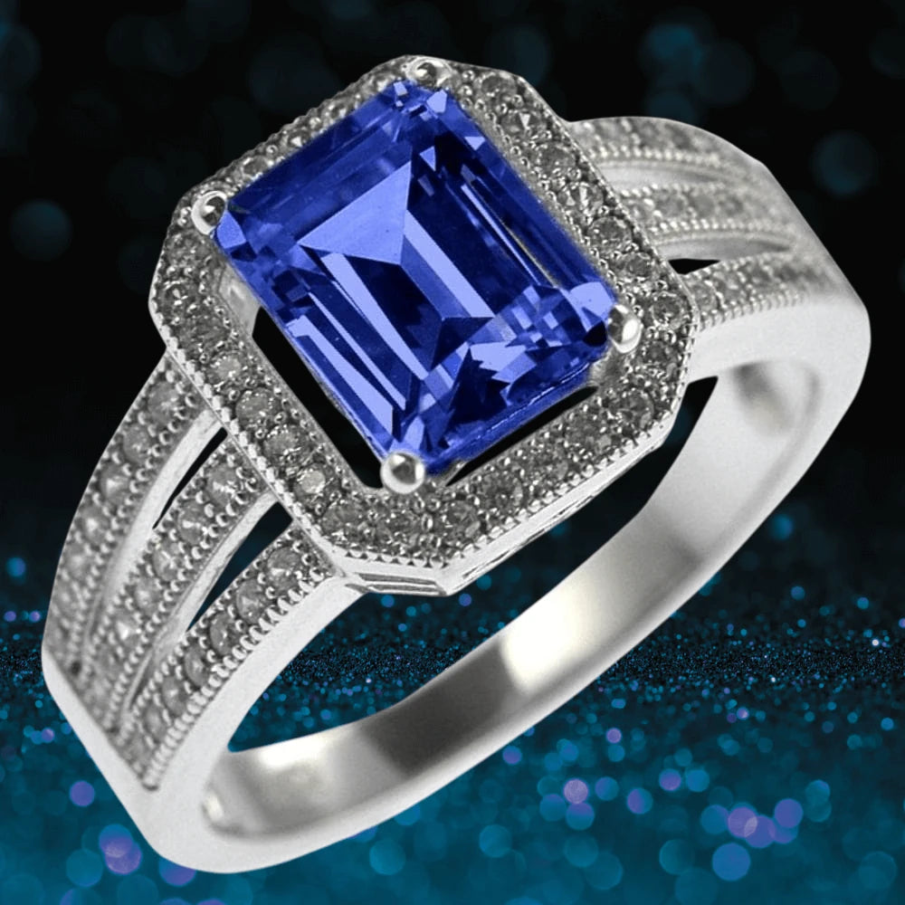 Artica Sapphire Ring featuring a sterling silver band with rhodium plating and a striking rectangular sapphire centerpiece surrounded by small sparkling stones.