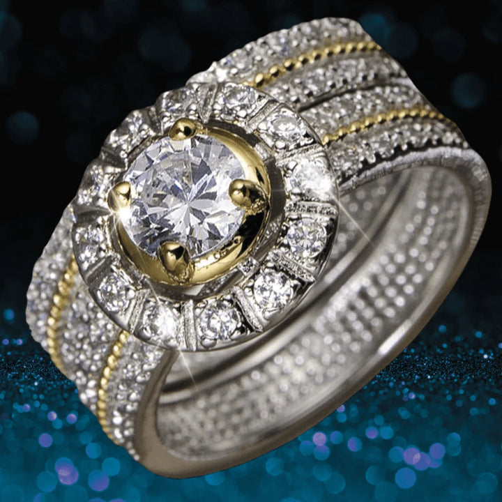 Antonia Ring featuring a two-tone sterling silver design with a central round clear gemstone surrounded by smaller sparkling stones in an elegant setting.