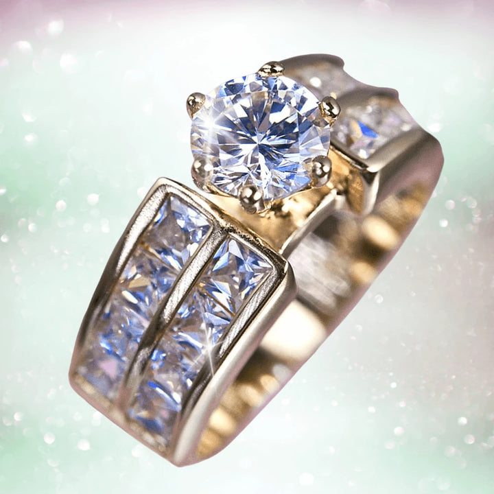 Garbo Ring featuring a sterling silver band with gold plating, adorned with a large round clear gemstone centerpiece and smaller square-cut stones embedded along the band.