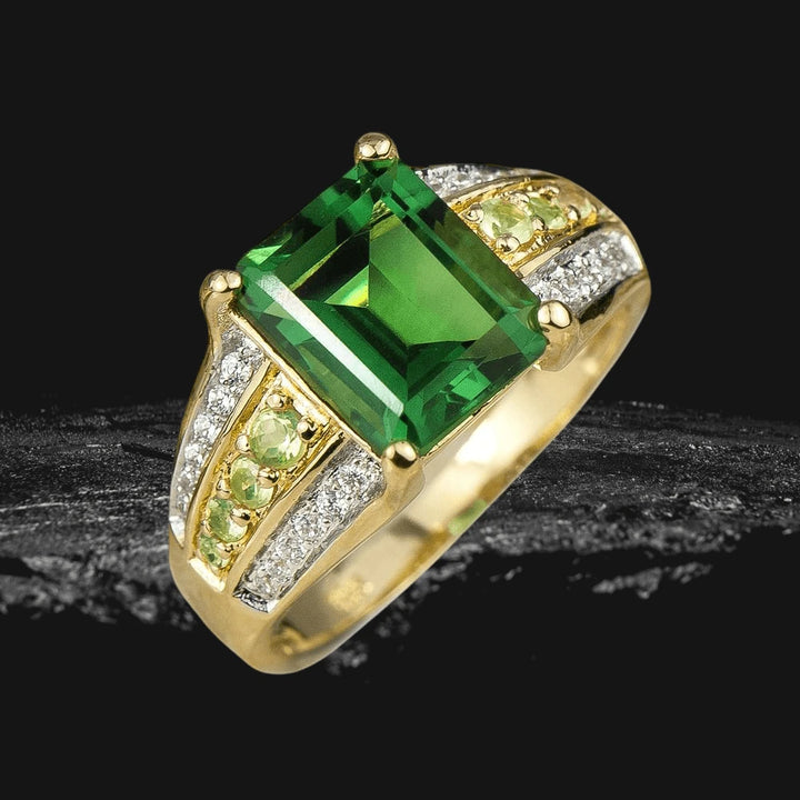 Belvedere Ladies Ring featuring a large rectangular green gemstone set in sterling silver with gold plating, accented by smaller green and clear stones for an elegant look.