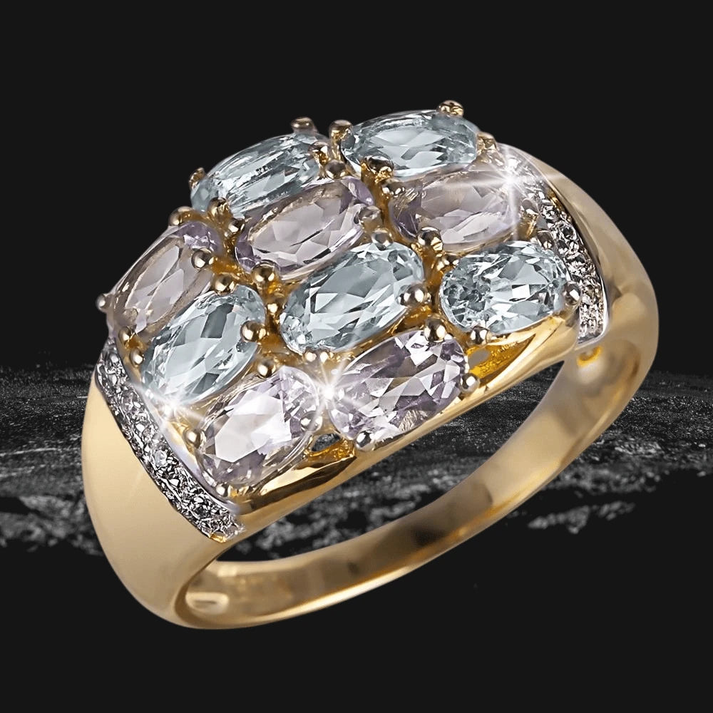 Wysteria Sky Ring featuring a sterling silver band plated in gold with multiple oval-cut light blue and lavender gemstones, designed for women’s elegant jewelry collection.
