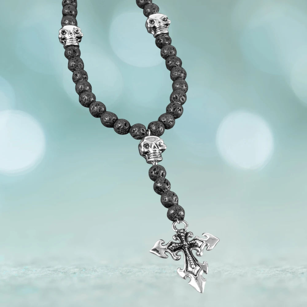 Skull Lava Rosary featuring stainless steel skull accents and a detailed cross pendant on textured black lava beads, a striking men’s jewelry piece.
