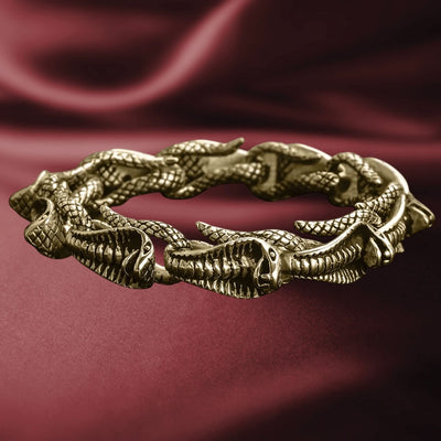 Venom Men's Gold Bracelet made from stainless steel with a gold plating, featuring an intricate design of connected serpent heads, displayed on a rich burgundy fabric background.