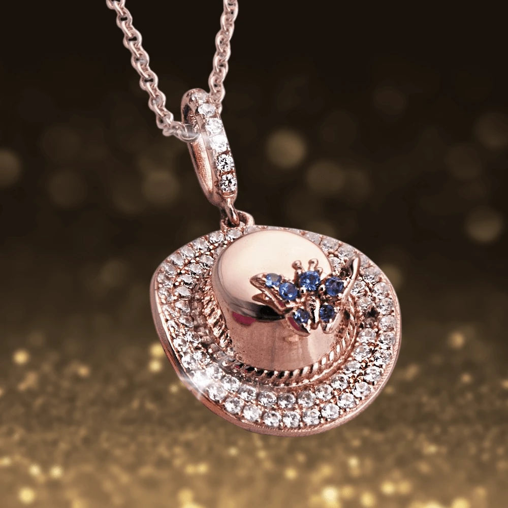 Memories Of Summer Pendant in sterling silver with rose gold plating, featuring a detailed hat design embellished with sparkling crystals and blue gemstone accents on a delicate chain.