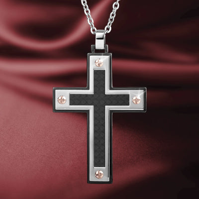 Dynamo Men's Pendant featuring a stainless steel cross design with black center and four rose gold-tone screws, hanging on a matching chain over a deep red fabric background.