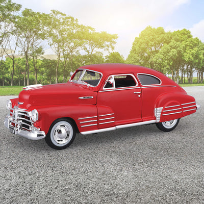 Red die cast model of the 1948 Chevrolet Fleetline Aerosedan displayed outdoors with trees in the background, Unisex collectible, Up To 75% Off Retail.