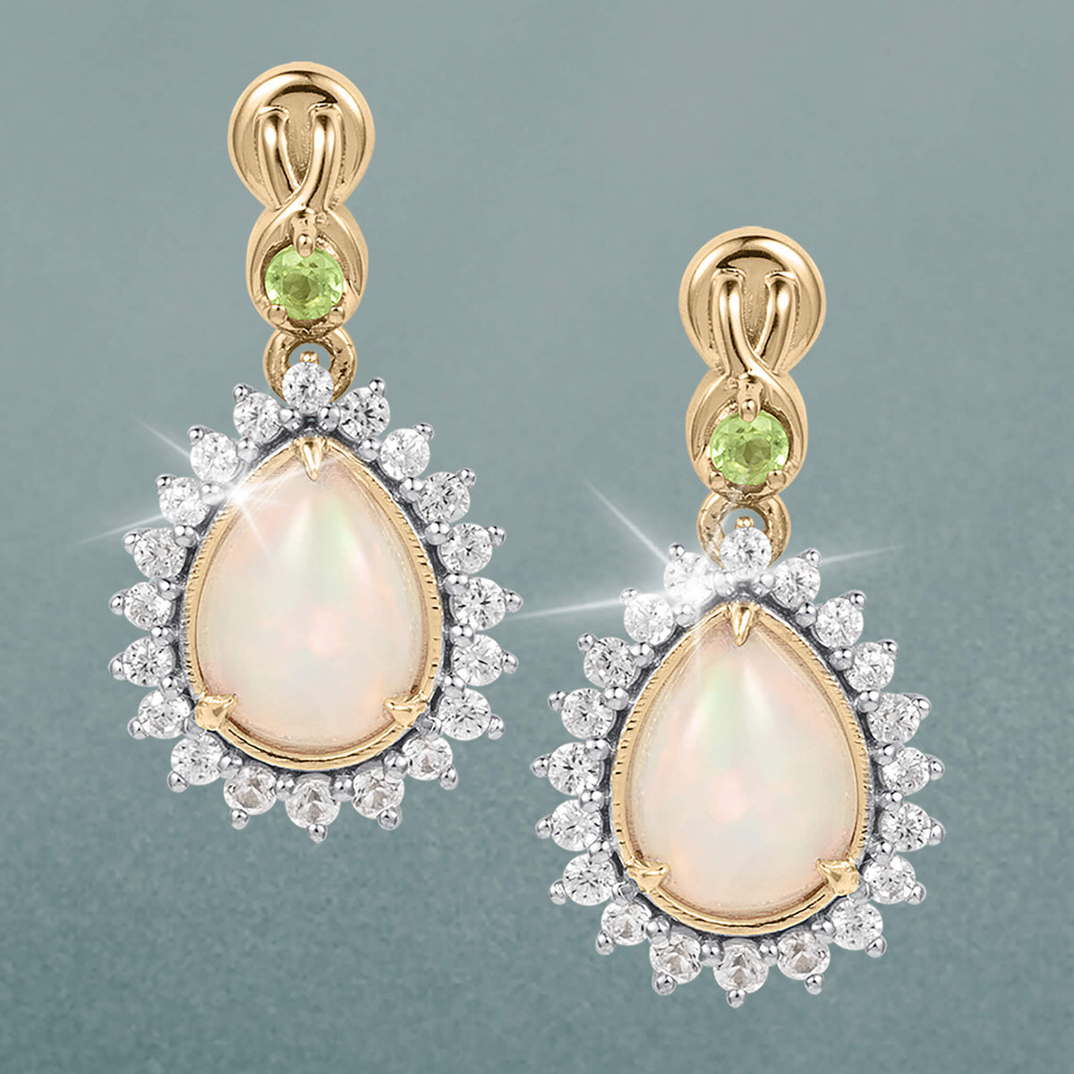 Opal Dew Drop Earrings featuring pear shaped opal drops framed by sparkling round stones with gold tone accents and green gemstone details