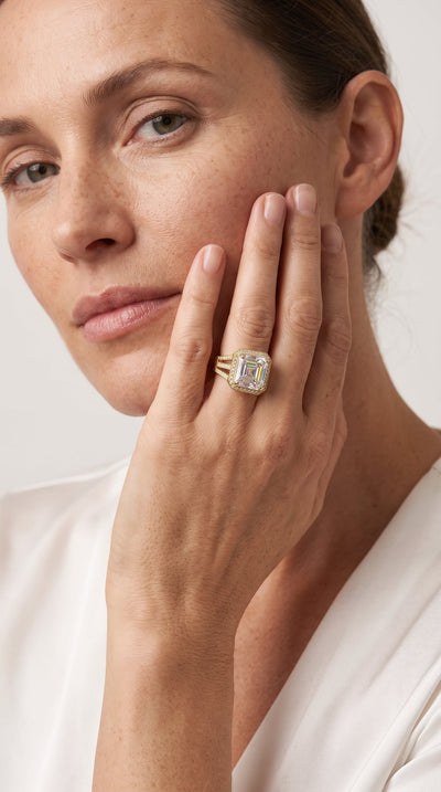 Woman wearing a large gold and diamond Solace Sparkle Ring on her finger, showcasing jewelry elegance with a tagline Up To 75% Off Retail.