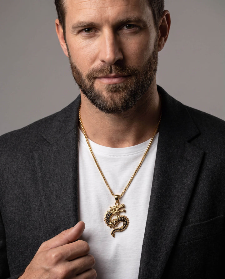 Man wearing a gold Dragonforge Pendant necklace with a detailed dragon design, paired with a white shirt and dark blazer, Up To 75% Off Retail.