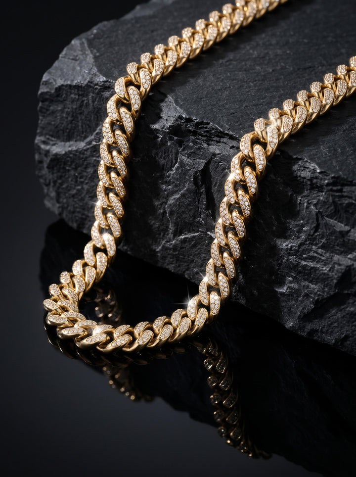 Magnus Necklace featuring a polished gold tone Cuban link design with sparkling accents styled on black stone for a bold luxurious jewelry presentation