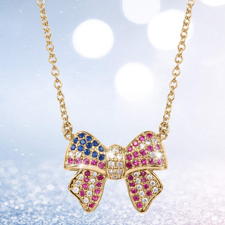 Delicate Heritage Bow Necklace featuring a gold-tone bow pendant adorned with blue, pink, and clear sparkling stones on a fine chain, perfect for elegant jewelry lovers.