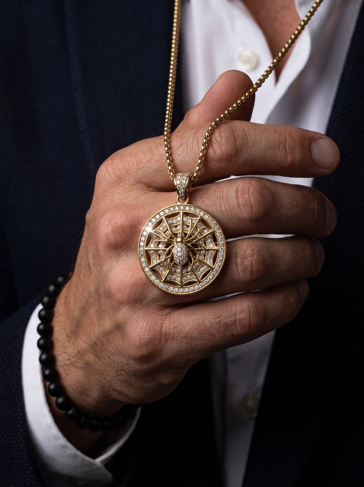 The Webmaster Pendant ornate circular gold necklace pendant with intricate web design and sparkling accents held in a hand Up To 75% Off Retail