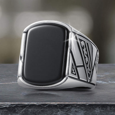 Close-up of a sleek Onyx Raven Men's Ring featuring a bold black onyx center stone and intricate silver detailing, available Up To 75% Off Retail.