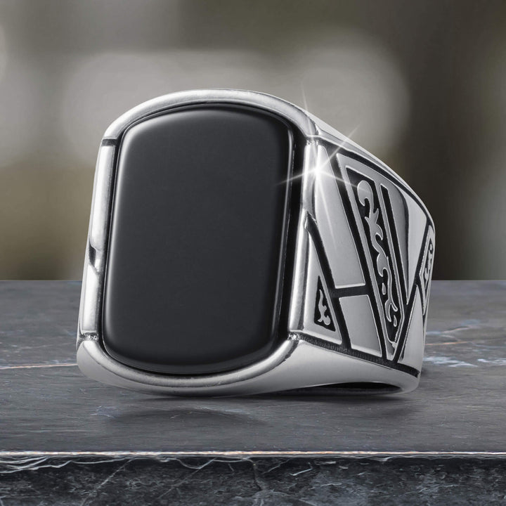 Close-up of a sleek Onyx Raven Men's Ring featuring a bold black onyx center stone and intricate silver detailing, available Up To 75% Off Retail.