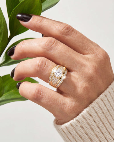 Nova Glow Ladies Ring in gold plating featuring a large central sparkling stone surrounded by smaller crystals worn on a female hand with dark polished nails Up To 75% Off Retail