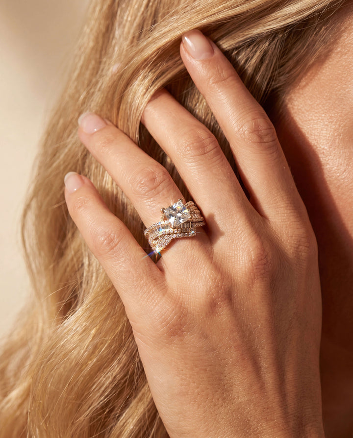 Close-up of a hand with a diamond ring on a neutral background