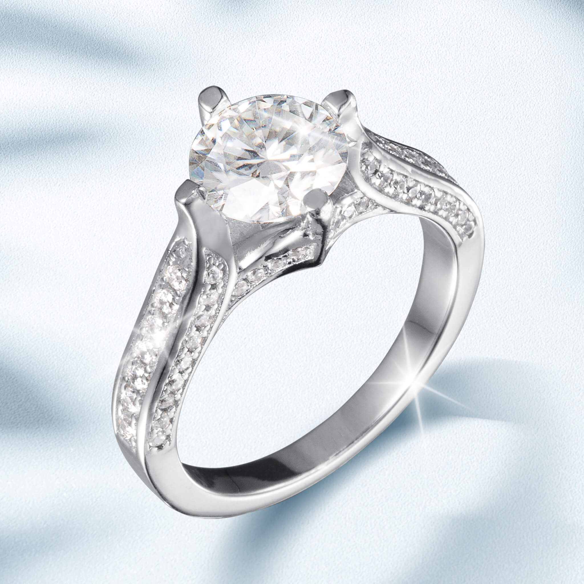 Novalyn Moissanite Ring featuring a large round center stone with a split shank band adorned with smaller sparkling accents in polished silver-tone metal.