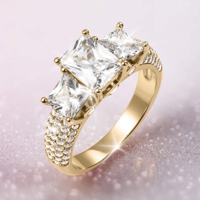 Verity Ladies Ring featuring a gold band with three large clear stones and multiple smaller stones along the shoulders, offering elegance Up To 75% Off Retail.