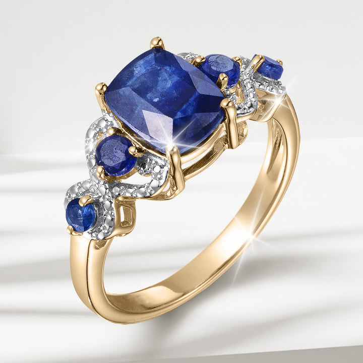 Elara Sapphire Ring featuring a large deep blue sapphire surrounded by smaller sapphires and diamonds in a polished gold setting Up To 75% Off Retail