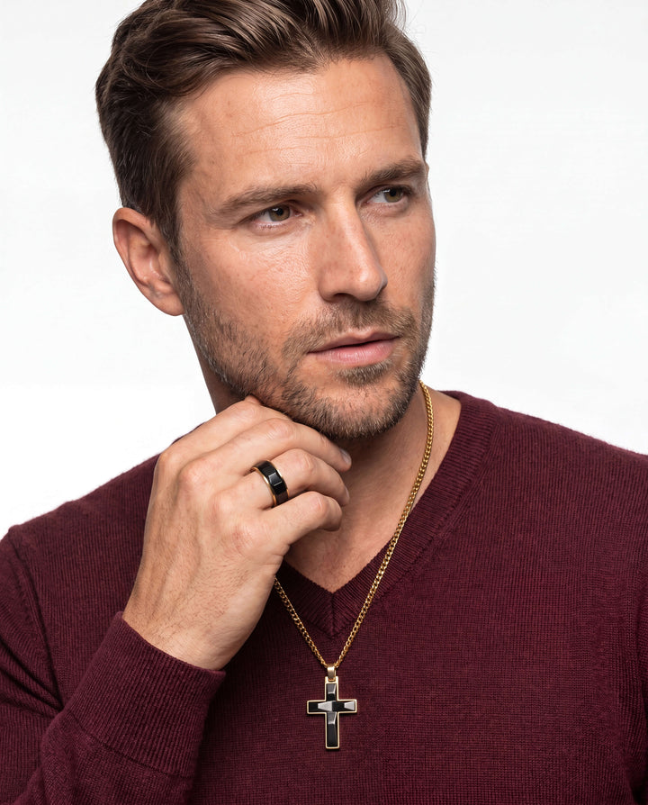 Male model wearing a gold-plated black cross pendant necklace and black ring from the Noir Legacy Collection, showcasing stylish jewelry with Up To 75% Off Retail.