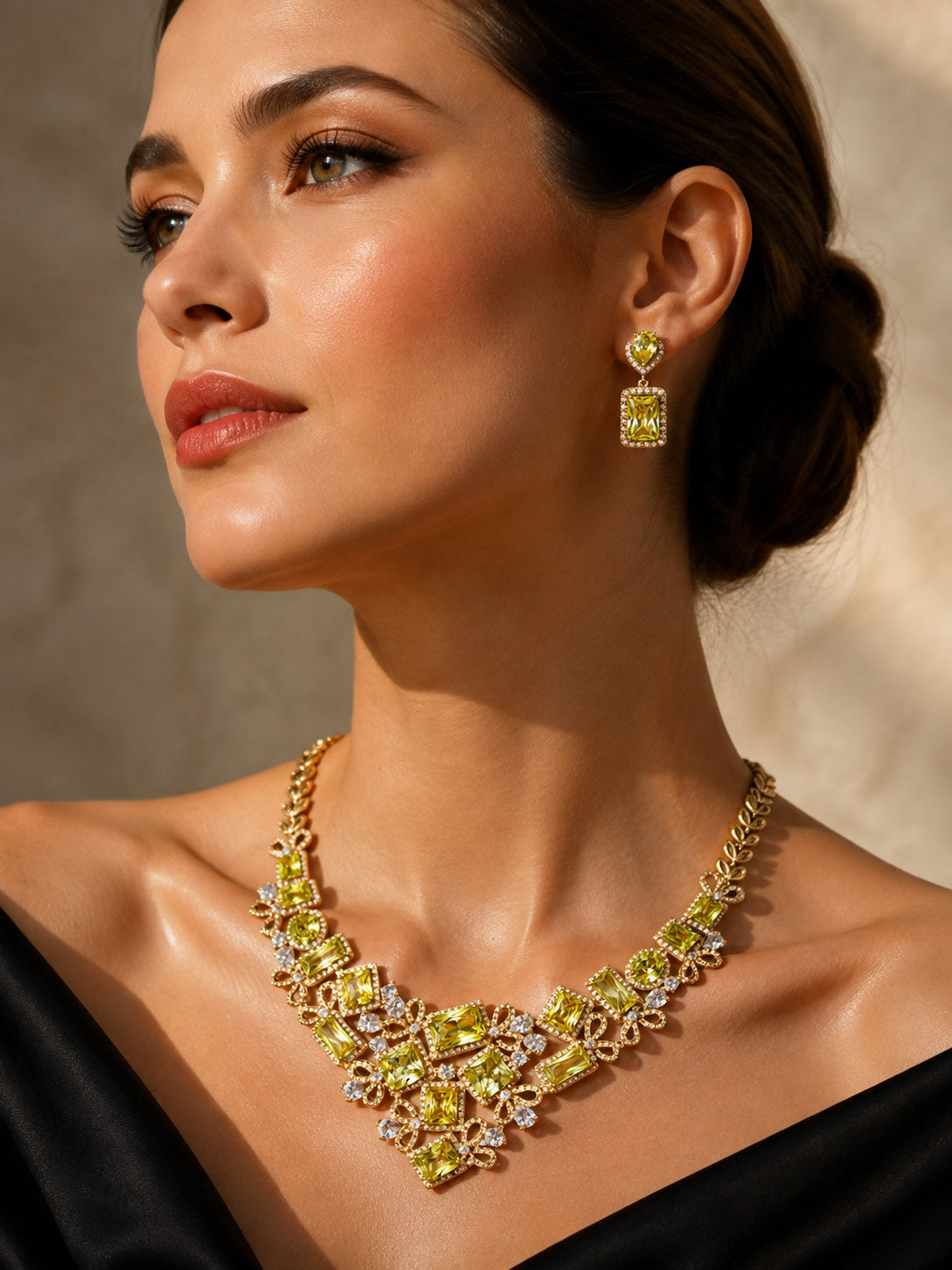 Golden Willow Necklace worn as an ornate gold statement necklace with sparkling floral details on a woman in an elegant black dress