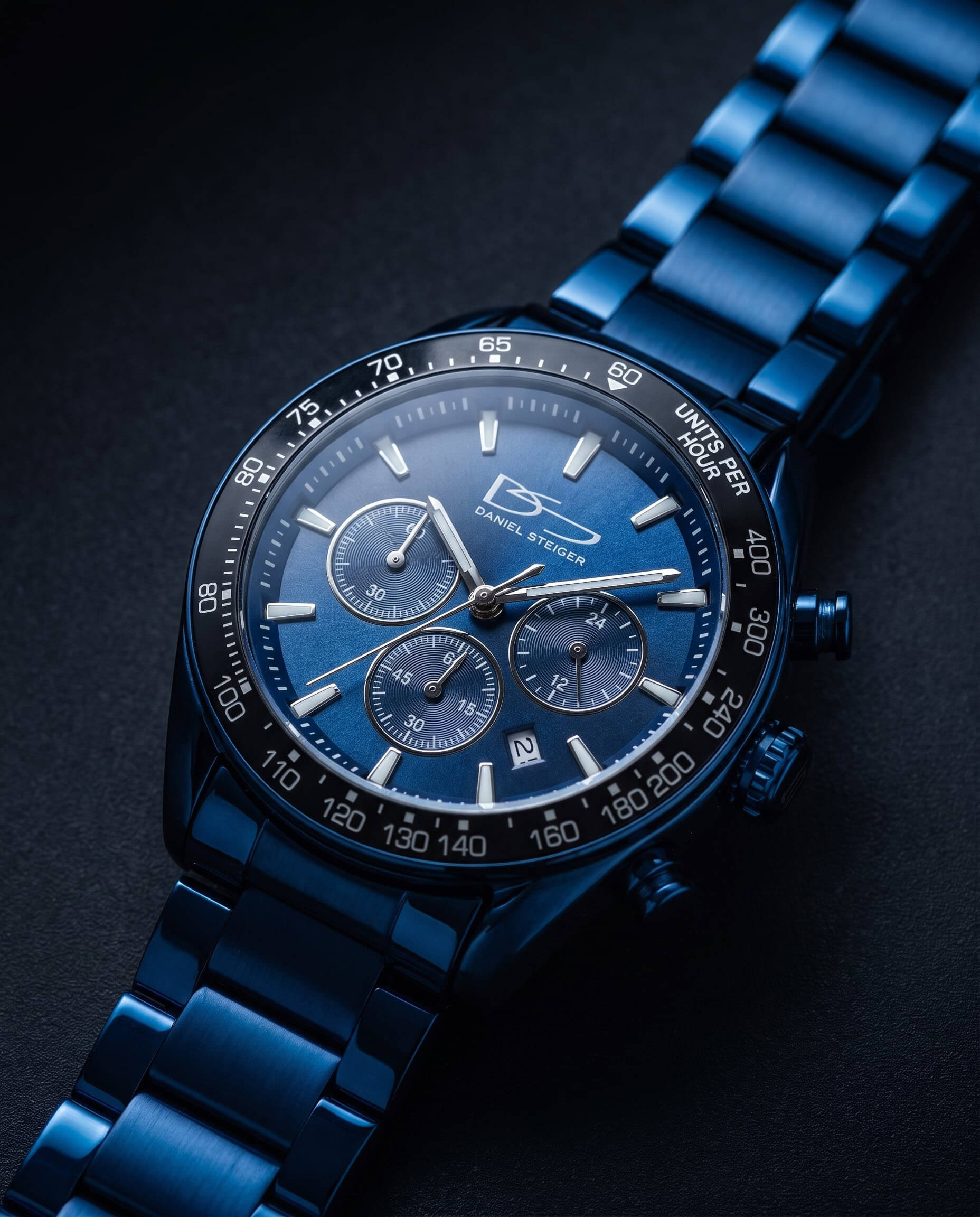Close-up of a sleek Midnight Velocity Men's Watch with a blue metal bracelet, detailed chronograph dials, and tachymeter bezel, showcasing precision and stylish design.