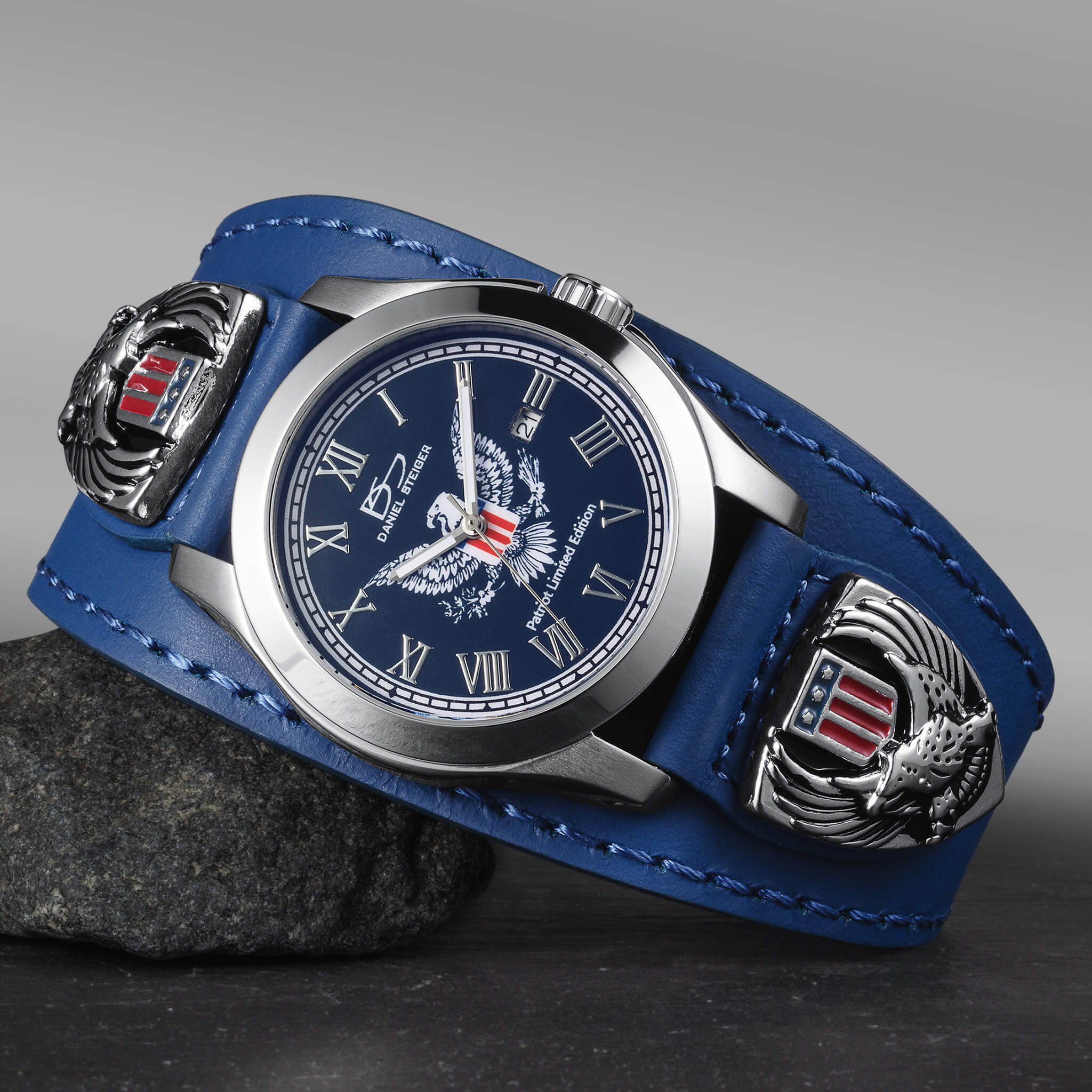 Wristwatch with blue leather strap and eagle emblem on a gray background