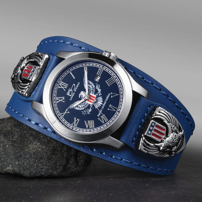 Wristwatch with blue leather strap and eagle emblem on a gray background