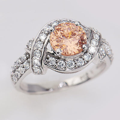 Lover's Knot Mandarin Ring featuring a round peach-colored center stone surrounded by sparkling clear accents set in rhodium-plated sterling silver for women’s jewelry.