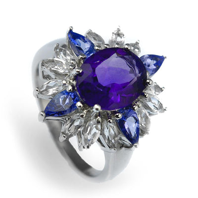 Super Nova Ring featuring a sterling silver band with rhodium plating, adorned with a large purple central gemstone surrounded by alternating blue and clear stones, designed for women’s jewelry.
