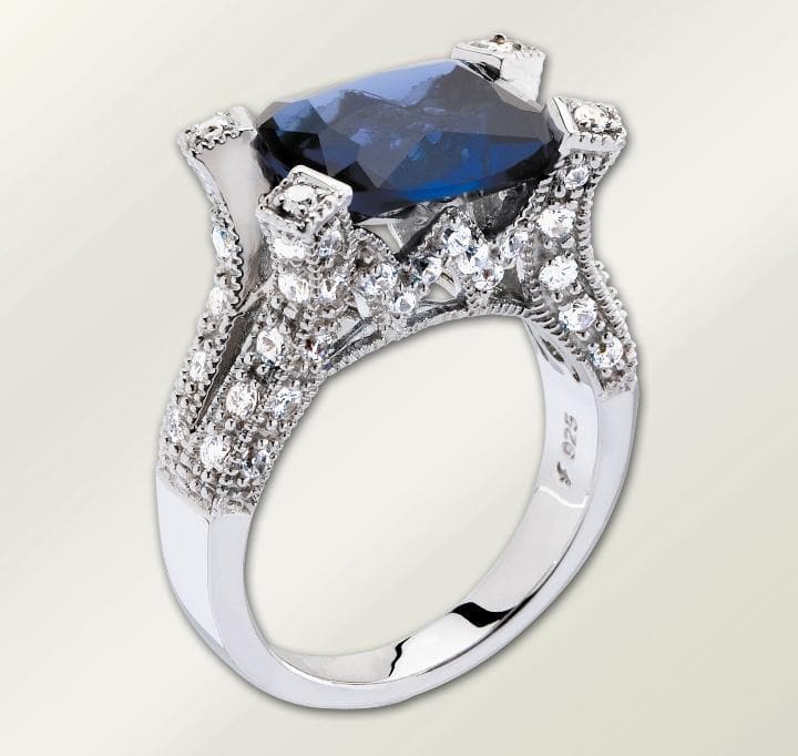 Millionaire Ring - Blue featuring a sterling silver band with intricate detailing and sparkling accents, showcasing a large blue gemstone centerpiece designed for female jewelry enthusiasts.