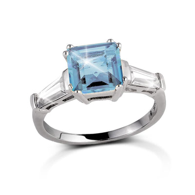 Decadence Gem Ring Blue Topaz featuring a square-cut blue topaz center stone set in sterling silver with rhodium plating, designed for women’s elegant jewelry collections.
