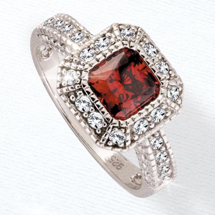 Regent Ring featuring a sterling silver band adorned with clear gemstones surrounding a deep red square-cut center stone, designed for women’s jewelry collections.
