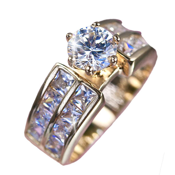 Garbo Ring featuring a large round-cut diamond centerpiece and channel-set smaller diamonds on a sterling silver band with gold plating, designed for women’s jewelry.