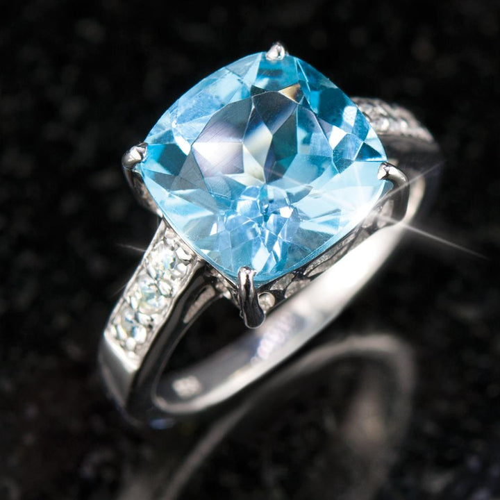 Sterling silver Swiss Topaz Cocktail Ring featuring a large cushion-cut blue topaz gemstone with sparkling side accents designed for female jewelry lovers.